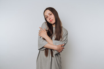 pensive young woman stands in a thoughtful pose, embodying vulnerability on white background