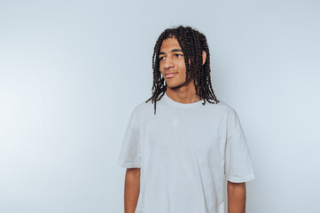 young man in a simple white t-shirt gives a friendly smile, standing on white background