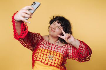 cheerful individual takes a selfie against a vibrant yellow backdrop, showcasing joy and confidence...