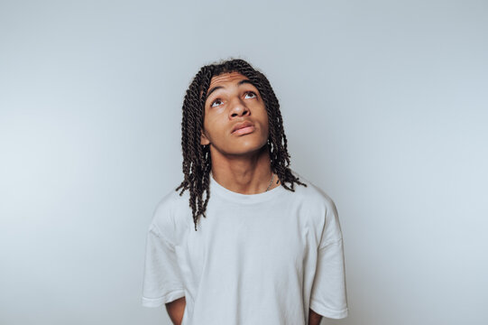 young man gazes upward with a contemplative expression, evoking curiosity and introspection on white background