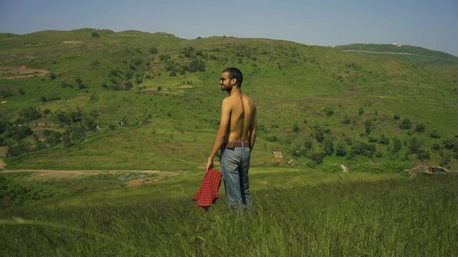 A young man gazing into the distance with stunning mountain views at Rayta Hills, Udaipur, Rajasthan, India.