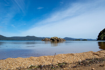 Serene Beach with Calm Waters and Distant Mountains