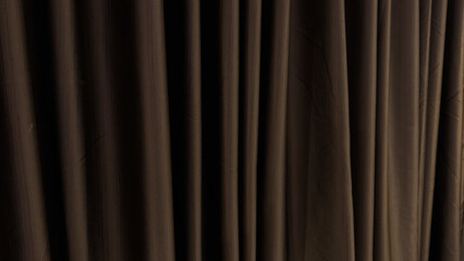A dark, richly textured curtain hangs vertically, displaying soft folds and subtle highlights,...