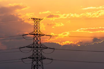 オレンジ色の夕焼け空と送電鉄塔のシルエット