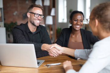 A positive handshake between colleagues in a modern office setting showcasing teamwork and collaboration