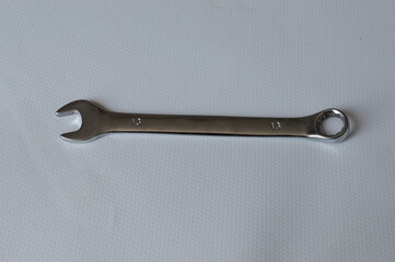 metal wrench with size marking 13 on a white background, ideal for themes like repair, mechanics,...