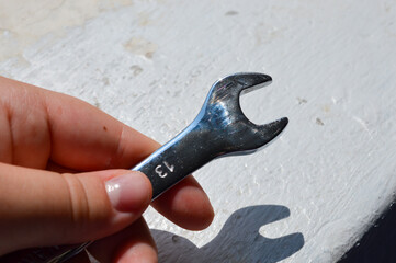 metal wrench with size marking 13 on a white background, ideal for themes like repair, mechanics,...