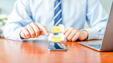Person using smartphone with floating digital files and laptop