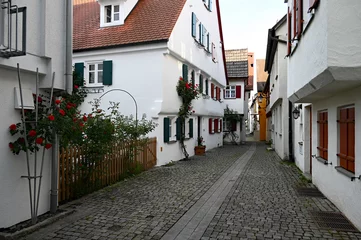 Fototapete A beautiful quaint old Bavarian town of Guenzburg with its narrow old streets and red roses clinging to the white historic houses (Guenzburg, Bavaria, Germany)  © Julia