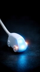 A white stylized car shaped USB drive with illuminated headlights on a dark textured surface