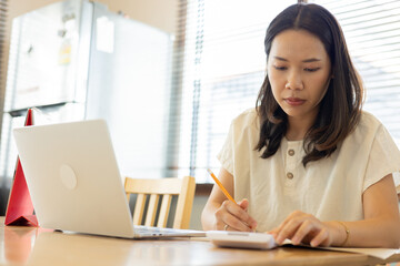 close up asian woman check debt or home loan with woman checklist and write about monthly expense in home for couple and family life concept