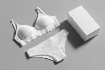 Elegant Lingerie Set: White undergarments with delicate lace trim, accompanied by a sleek gift box, against a minimalist grey backdrop.