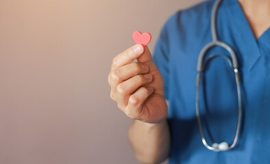close up specialist doctor man hand hold heart shape to represent of organ donation for health and life concept