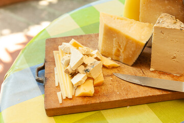 Cheese board with rustic knife and various cheese types ready for serving in natural setting