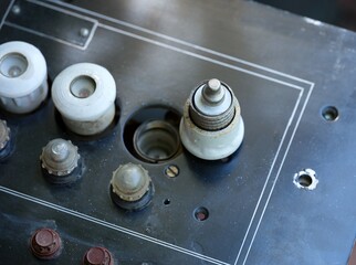 White ceramic plug fuse on an old black electrical panel
