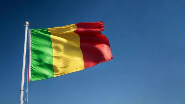 The flag of Mali, featuring green, yellow, and red stripes, waves joyfully against a bright blue sky on independence Day. - Powered by Adobe