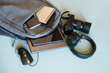 Urban backpack showcasing essential gadgets for tech-savvy individuals, including notebook, pen, and power bank for study or travel. Photo. High resolution