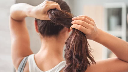Fotobehang Kapsalon Young woman tying her long hair   © sebra