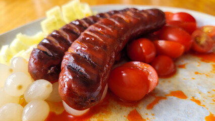Grilled Sausages with Cherry Tomatoes, Onions, and Cheese Cubes on Plate