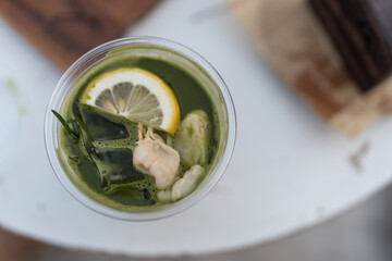 Top view of a glass of iced Matcha green tea with lemon and lychee, a refreshing drink