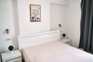Minimalist bedroom with white furniture and wall art