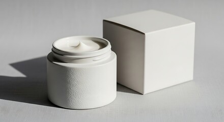 Minimalist skincare: White cream jar and packaging box under natural lighting