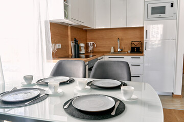 Modern minimalist kitchen interior with elegant dining setup in bright natural light