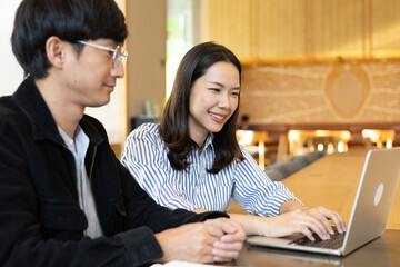 close up businesswoman work on laptop and talk or consult about new marketing plan project with businessman for business advice and team concept