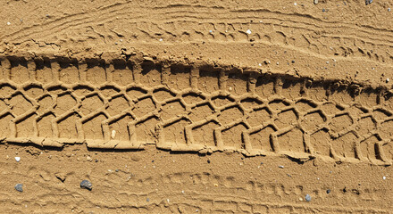 Off road vehicle tire track pattern imprinted deeply onto sandy terrain texture surface