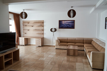Modern living room with beige sofas and wooden decor elements in a bright space