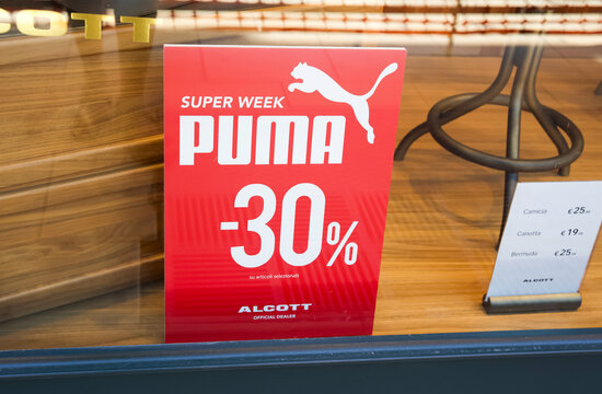 Messina, Italy - June 28, 2025: Promotional sign for Puma featuring discount details at Alcott store with wooden display background
