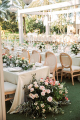 Wedding reception table decorated with elegant floral arrangements, tall glass candlesticks, and soft candlelight. Romantic and festive atmosphere perfect for celebrations and luxury wedding design.