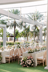 Wedding reception decoration with tall candlesticks, floral arrangements, and soft ambient lighting. Romantic detail symbolizing festive atmosphere and celebration.