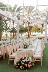  Luxury wedding banquet hall decorated with floral arrangements, round tables, and elegant lighting. Stylish event interior creating a festive and romantic atmosphere for celebration.