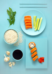 Creative food health diet concept photo of dishes sushi rolls with vegetables and fish salmon on blue background.