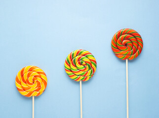 Creative food health diet concept photo of lolli pop popsicle candy on blue background Christmas holiday celebration.
