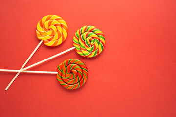Creative food health diet concept photo of lolli pop popsicle candy on red background Christmas holiday celebration.