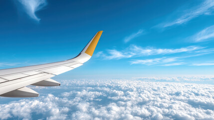 Fototapeta premium Aerial view of airplane wing above fluffy clouds and bright blue sky, evoking sense of freedom