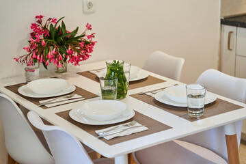 Elegant table setting with white dinnerware and fresh floral arrangement