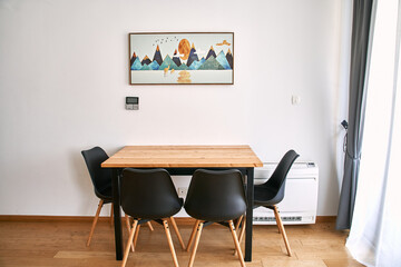 Minimalist dining room with wooden table and black chairs in modern home decor