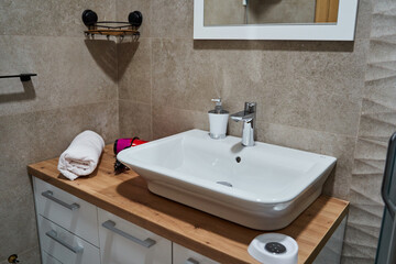 Modern bathroom: minimalist vanity, towel, soap dispenser, neutral tones, elegant design