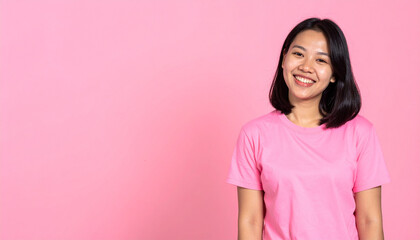 Fototapeta premium Happy woman smiling in pink shirt against pink background
