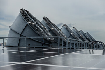 Cooling fans are installed on rooftop of large commercial building. Maintaining air circulation and temperature control. Tower air chiller HVAC.