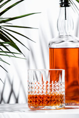 Enjoying a glass of rich and smooth scotch whiskey in a stylish setting surrounded by lush greenery