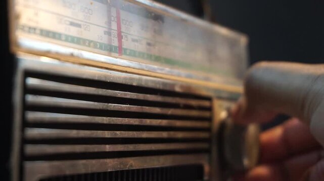 Close-up of vintage radio being tuned with focus on frequency bar, retro audio equipment scene ideal for nostalgia, broadcast, or analog concept footage