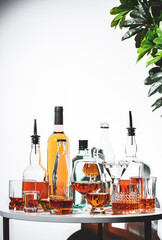 Selection of strong alcoholic drinks displayed on a table with various glasses and bottles...