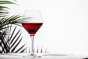 Elegant non-alcoholic red wine served in a crystal glass against a minimalist white background