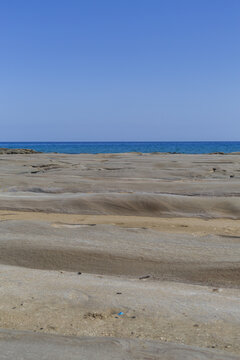 View of the desolate, sandy landscape meets the turquoise sea under a clear blue sky, creating a serene yet stark contrast, Dipkarpaz, Northern Cyprus, Cipro.