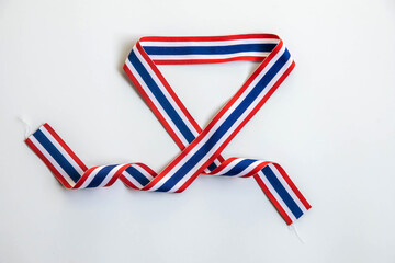 Thai flag striped ribbon shaped into a heart on a white background. Represents national pride,...