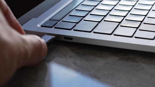 Connecting a USB adapter to a laptop.
Type-c connector in a laptop for connecting a cable and accessories.
Connecting a cable to a type-c connector on a laptop
